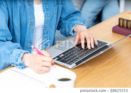 一邊做筆記一邊用筆記本電腦的女人的手[零件切割] 88625553