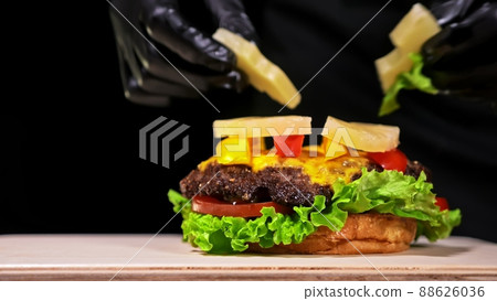 Craft burger is cooking. Consist: red sauce salsa, lettuce, red onion, pickle, cheese, chilli green pepper, air bun and marbled meat beef. Craft burger is cooking. Consist: red sauce salsa, lettuce, red onion, pickle, cheese, chilli green pepper, air bun and marbled meat beef. 88626036