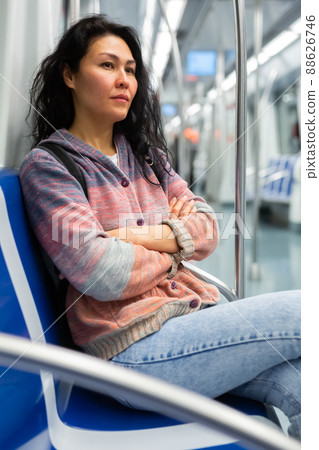 Woman with backpack sitting on bench in metropolitan train 88626746
