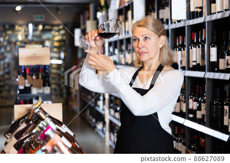 Cheerful woman sommelier tasting natural wines 88627089