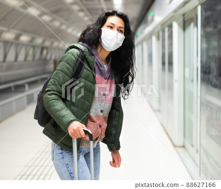 Oriental woman in protective mask going along just arrived train 88627166