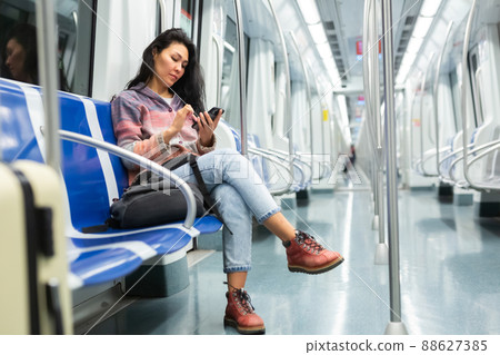 Woman passenger using phone in subway car 88627385