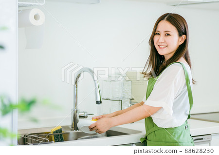 Woman washing dishes (looking at the camera) Woman washing dishes (looking at the camera) 88628230