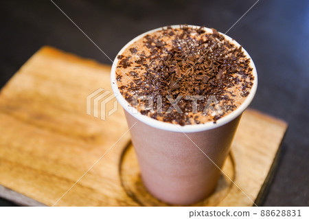 Specialty crafted hot chocolate beverage service on the wooden plate close up. A professional barista brewing a special hot chocolate in the cafe and restaurant. 88628831