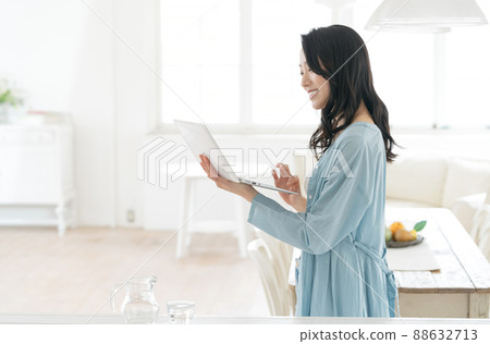 A young woman looking at a computer in the living room A young woman looking at a computer in the living room 88632713