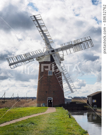 The sails of Horsey Windpump against a blue sky with white clouds, Norfolk The sails of Horsey Windpump against a blue sky with white clouds, Norfolk 88632762