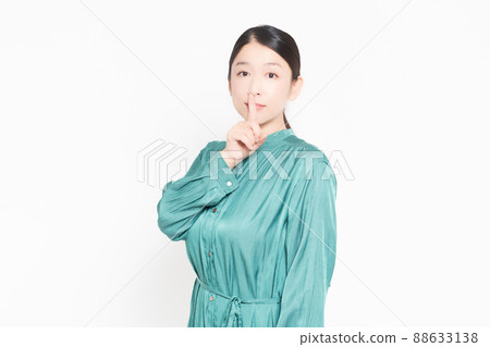 一個家庭主婦,她用手摀著嘴,擺出一個秘密的姿勢 一個家庭主婦,她用手摀著嘴,擺出一個秘密的姿勢 88633138
