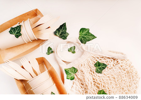Fabric bag for food delivery.Eco craft paper tableware.Paper cups,fast food containers.Recycling,eco-friendly concept.Disposable eco cutlery,plates,spoons,knives,forks on a light background.Copy space 88634009