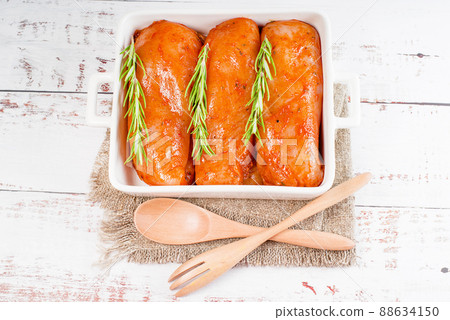 Raw marinated chicken fillet in red sauce in a roasting plate Fresh marinated chicken for roasting. Diet meat. 88634150