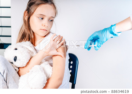 Vaccinations for children. The child was given a vaccine.Female doctor or nurse trying to give shot or vaccine against virus to a scared patient. Angry and distrustful patient refuses to receive it. 88634619