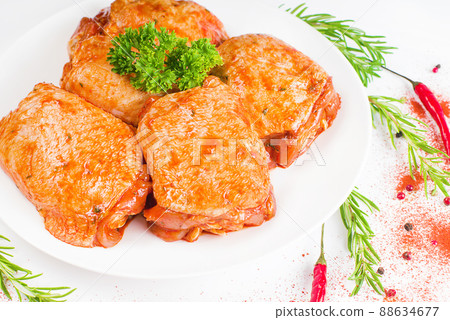 Chicken thighs marinated in red sauce on a white plate,on white background,banner.Convenience food, quick cook, semi-cooked food. 88634677