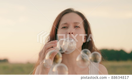 woman blowing soap bubbles park. festive mood. women outdoor recreation. happy woman vacation travel. beautiful transparent balloons outdoors. fun relaxing fun game play. holiday entertainment dream. 88634817