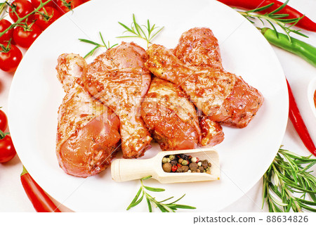 Cooking chicken drumsticks.Raw chicken legs in a marinade with rosemary and pepper.Top view.Hot grilled chicken leg.Raw chicken legs. Delicious marinated chicken legs . 88634826