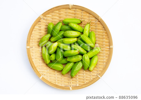 Bilimbi fruit in bamboo basket on white background. 88635096