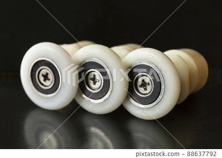 White roller with screw on black background 88637792