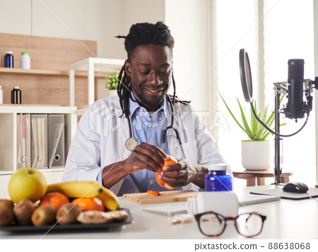 young nutritionist take a break in office and eat a tangerine young nutritionist take a break in office and eat a tangerine 88638068