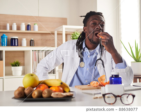young nutritionist take a break in office and eat a tangerine 88638077