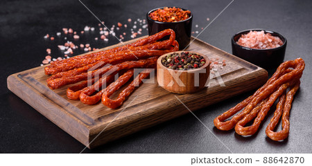 Smoked hunting sausages on a black stone background. Top view. Free copy space Smoked hunting sausages on a black stone background. Top view. Free copy space 88642870