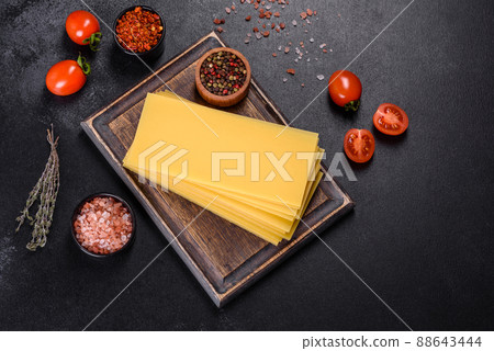 Stack of lasagna sheets on a dark concrete background. Ingredients for lasagna 88643444