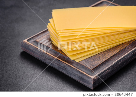 Stack of lasagna sheets on a dark concrete background. Ingredients for lasagna Stack of lasagna sheets on a dark concrete background. Ingredients for lasagna 88643447