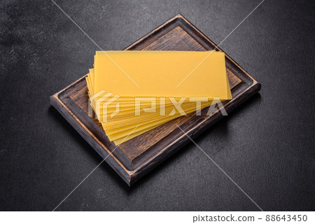 Stack of lasagna sheets on a dark concrete background. Ingredients for lasagna Stack of lasagna sheets on a dark concrete background. Ingredients for lasagna 88643450