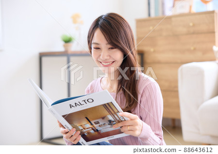 A woman reading a book in the living room 88643612