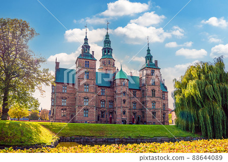 Old brick Rosenborg Castle with museum in the Kings gardens park with green bushes and trees. Copenhagen, Denmark 88644089