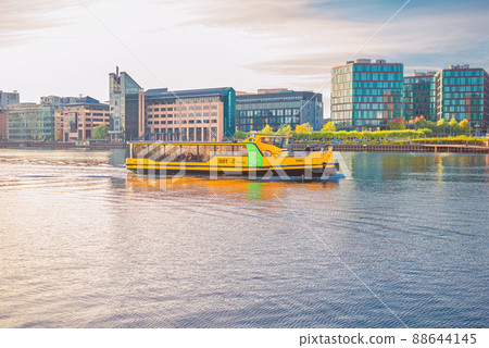 Yellow Copenhagen Harbour water Busesthe sails along the city canal harbourfront near residential buildings of Copenhagen, Denmark Yellow Copenhagen Harbour water Busesthe sails along the city canal harbourfront near residential buildings of Copenhagen, Denmark 88644145