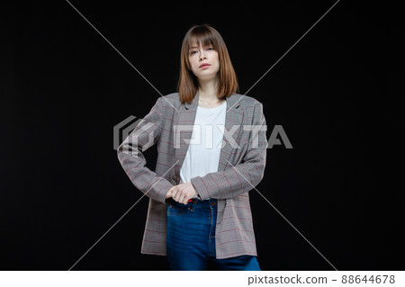 Portrait of a young modern business woman in a jacket on a black isolated background. Portrait of a young modern business woman in a jacket on a black isolated background. 88644678