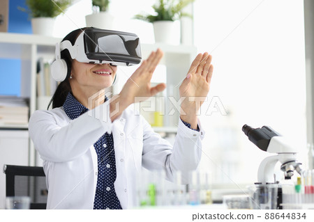 Doctor wearing virtual glasses in virtual reality in laboratory Doctor wearing virtual glasses in virtual reality in laboratory 88644834