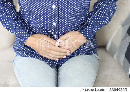 Women hands on stomach with painful spasms closeup Women hands on stomach with painful spasms closeup 88644835