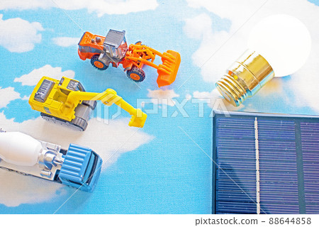 Blue sky, solar panels, light bulbs, and toys for large vehicles that are active in the construction and civil engineering businesses. 88644858