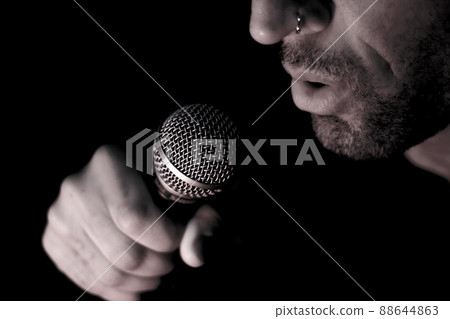 Singer man with round microphone on dark background 88644863