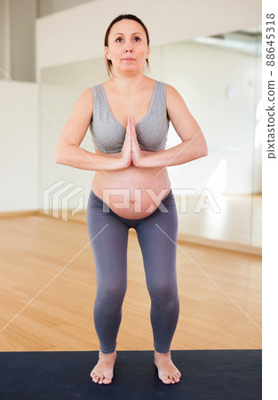 Pregnant woman is engaged in yoga. Utkatasana or Chair Pose Pregnant woman is engaged in yoga. Utkatasana or Chair Pose 88645318