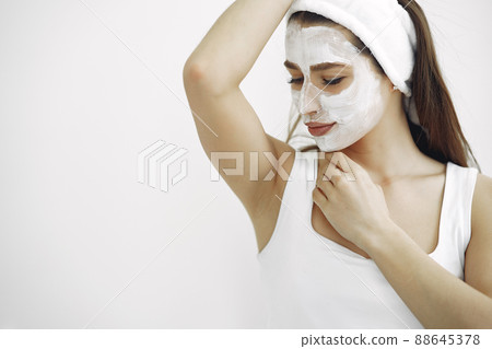 Cosmetology theme. Girl in a white bandage. Woman with mask on face. Cosmetology theme. Girl in a white bandage. Woman with mask on face. 88645378