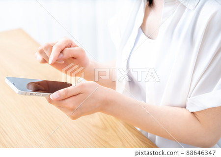 Hands of women who use smartphones at the table [Parts cut] 88646347