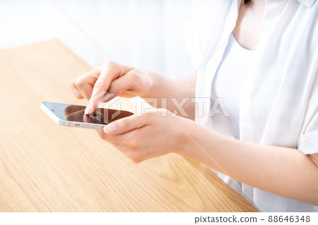 Hands of women who use smartphones at the table [Parts cut] 88646348