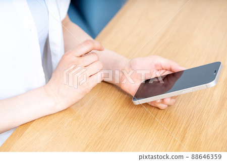 Hands of women who use smartphones at the table [Parts cut] 88646359