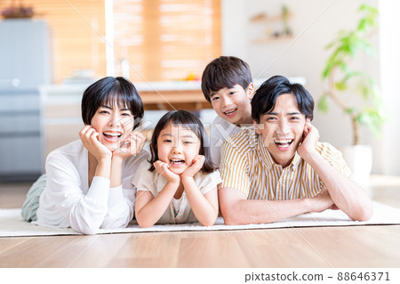 A family of four lying down in the living room 88646371