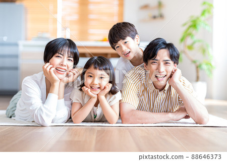 A family of four lying down in the living room 88646373