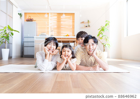 A family of four lying down in the living room 88646962