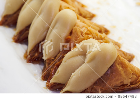 Greek dessert Trigona Panoramatos - crispy phyllo triangle pastries with custard. 88647488