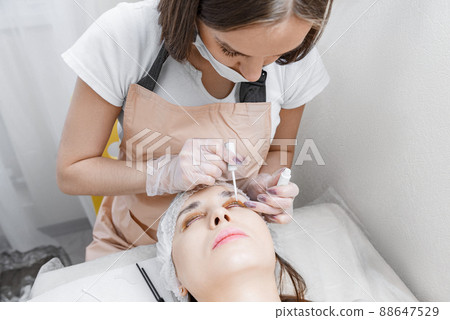 Master applies lamination glue to the clients eyelashes 88647529