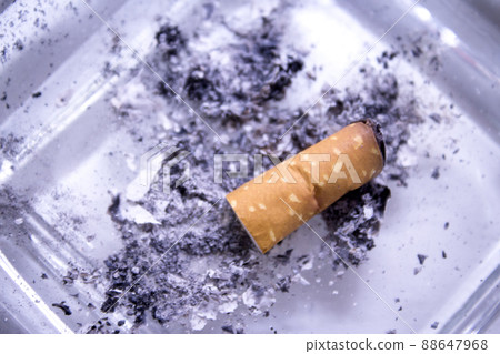 Cigarette consumed in an ashtray with ashes 88647968