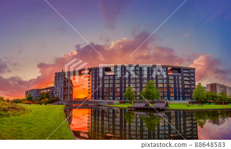lake and green field near Modern residential building on Tom Kristensens street in orestad city area at sunset. Copenhagen, Denmark 88648583