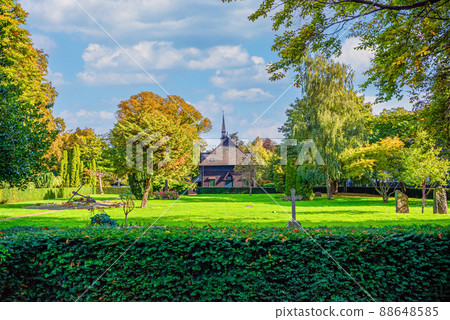 Lots of green trees, bushes, flowers and old chapel at Holmen Cemetery. Copenhagen, Denmark Lots of green trees, bushes, flowers and old chapel at Holmen Cemetery. Copenhagen, Denmark 88648585