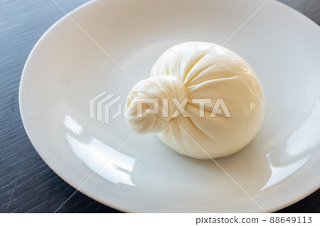 Buratta cheese on a white plate. Side view from above Buratta cheese on a white plate. Side view from above 88649113
