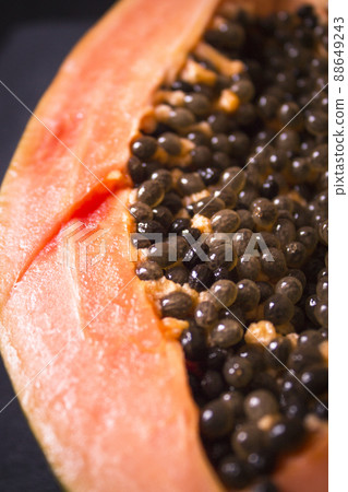 Half of an open papaya with the seeds 88649243