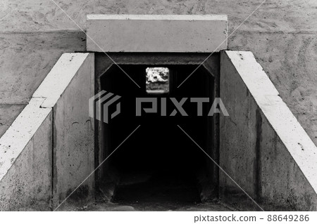 Large rectangular tunnel for water passage under railway tracks. The view from outside. Black and white photo. 88649286