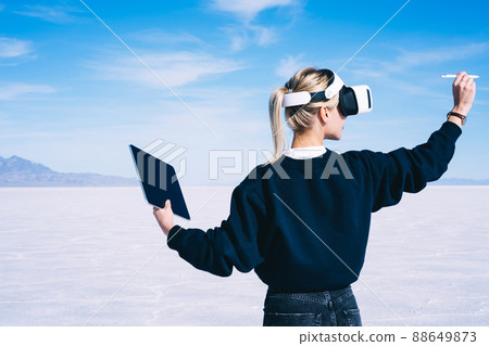 Female traveler exploring virtual reality with modern devices in salt pan Female traveler exploring virtual reality with modern devices in salt pan 88649873